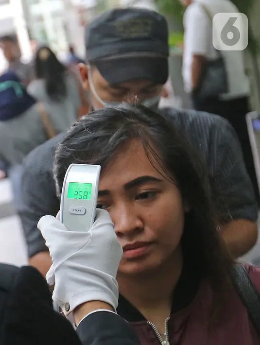 Pengunjung saat diperiksa suhu tubuh sebelum memasuki area gedung The Plaza di Jakarta, Kamis (5/3/2020). Pemeriksaan suhu tubuh tersebut merupakan upaya untuk mengantisipasi merebaknya wabah virus corona atau Covid-19. (Liputan6.com/Herman Zakharia)