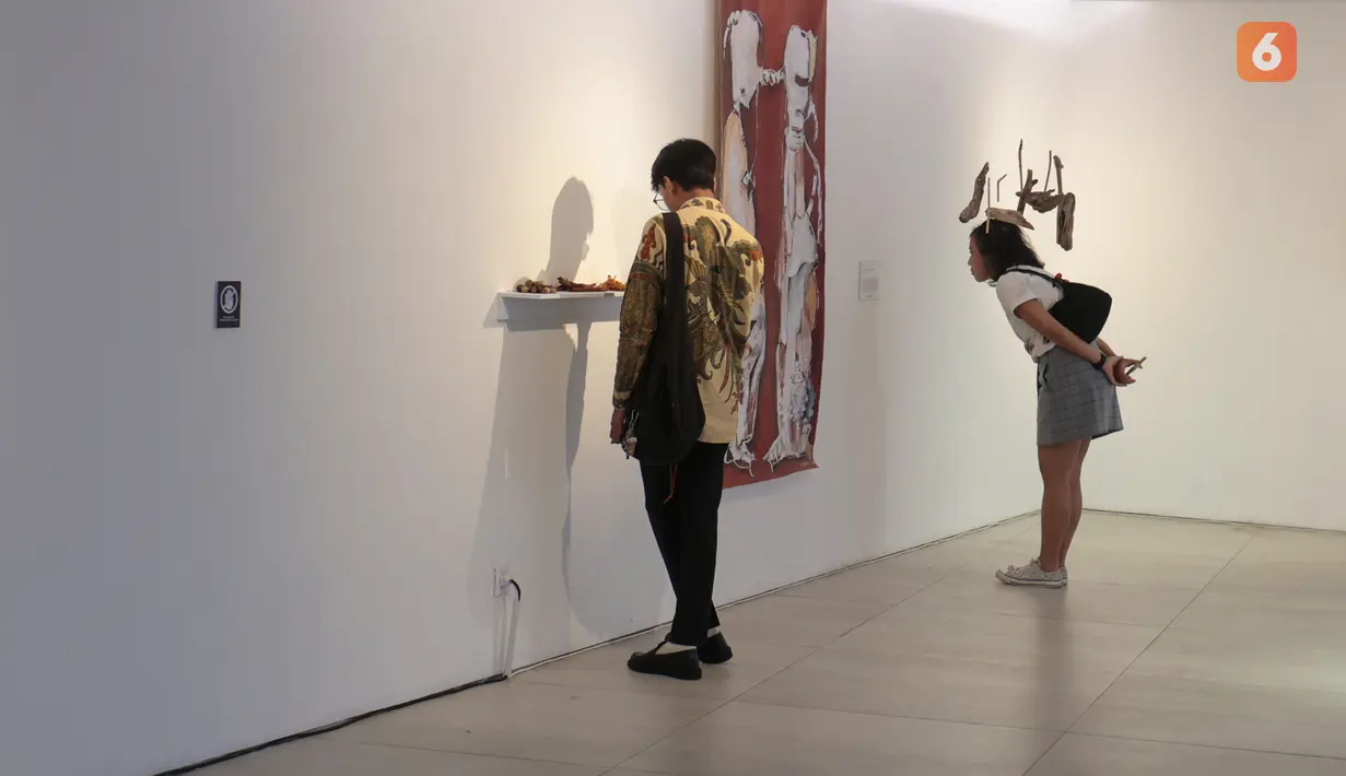 Dua orang pengunjung memperhatikan salah satu karya seni yang dipamerkan dalam Jakarta Biennale 2026 bertajuk “KEBAL” di Gedung Trisno Soemardjo, Taman Ismail Marzuki, Jakarta Pusat, Jumat (9/10/2026). Pameran ini menghadirkan karya seni rupa kontemporer dari seniman lokal dan internasional. (KLY/Budy Santoso)