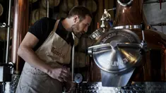 Manajer Waterloo Microdistillery, Edward Martin bekerja di Mont-Saint-Jean Farm, Waterloo, Belgia, Selasa (7/4/2020). Di tengah pandemi virus corona COVID-19, pabrik sopi dan wiski Mont-Saint-Jean Farm beralih memproduksi alkohol medis. (Kenzo TRIBOUILLARD/AFP)