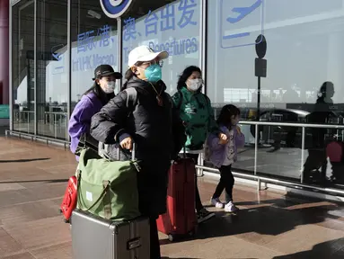 Penumpang yang memakai masker berjalan melalui terminal bandara Ibukota di Beijing, China, Selasa (13/12/2022). Pada Rabu (28/12/2022) AS mengumumkan persyaratan pengujian COVID-19 baru untuk semua pelancong dari China, bergabung dengan negara lain yang memberlakukan pembatasan karena dari lonjakan infeksi. (AP Photo/Ng Han Guan)