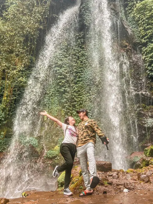 Seru liburan bareng ke Karanganyar, Jawa Tengah. Dalam liburannya ini keduanya mengunjungi salah satu destinasi wisata alam yang cukup populer di Karanganyar. Seru merasakan udara sejuk dekat air terjun, keduanya abadikan momen di depan Air Terjun Jumog. (Liputan6.com/IG/@viavallen)