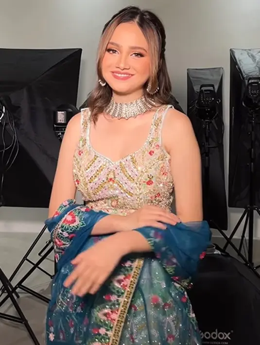 Syifa Hadju tampil menawan dalam balutan kain sari bernuansa emas dan biru. Penampilannya berkilau dengan atasan berwarna terang keemasan dengan bordir batu dan payet, dipadu rok dan selendang biru yang serasi. [Foto: Instagram/leoafandi_]