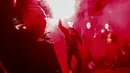 Pengunjuk rasa menyalakan suar saat memprotes perpanjangan lockdown atau penguncian ketat di Melbourne, Australia, Kamis (5/8/2021). Pemerintah Australia kembali memperpanjang lockdown di Melbourne selama sepekan untuk menekan penyebaran virus corona Covid-19 varian delta. (AFP/Con Chroinis)