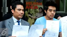 Martin Carter dan kuasa hukumnya menunjukkan surat usai keluar dari Sentra Pelayanan Kepolisian, Polda Metro Jaya, Jakarta, Rabu (19/8/2015). Ia melaporkan sejumlah penyanyi terkait pemutaran lagunya tanpa izin. (Liputan6.com/Panji Diksana)