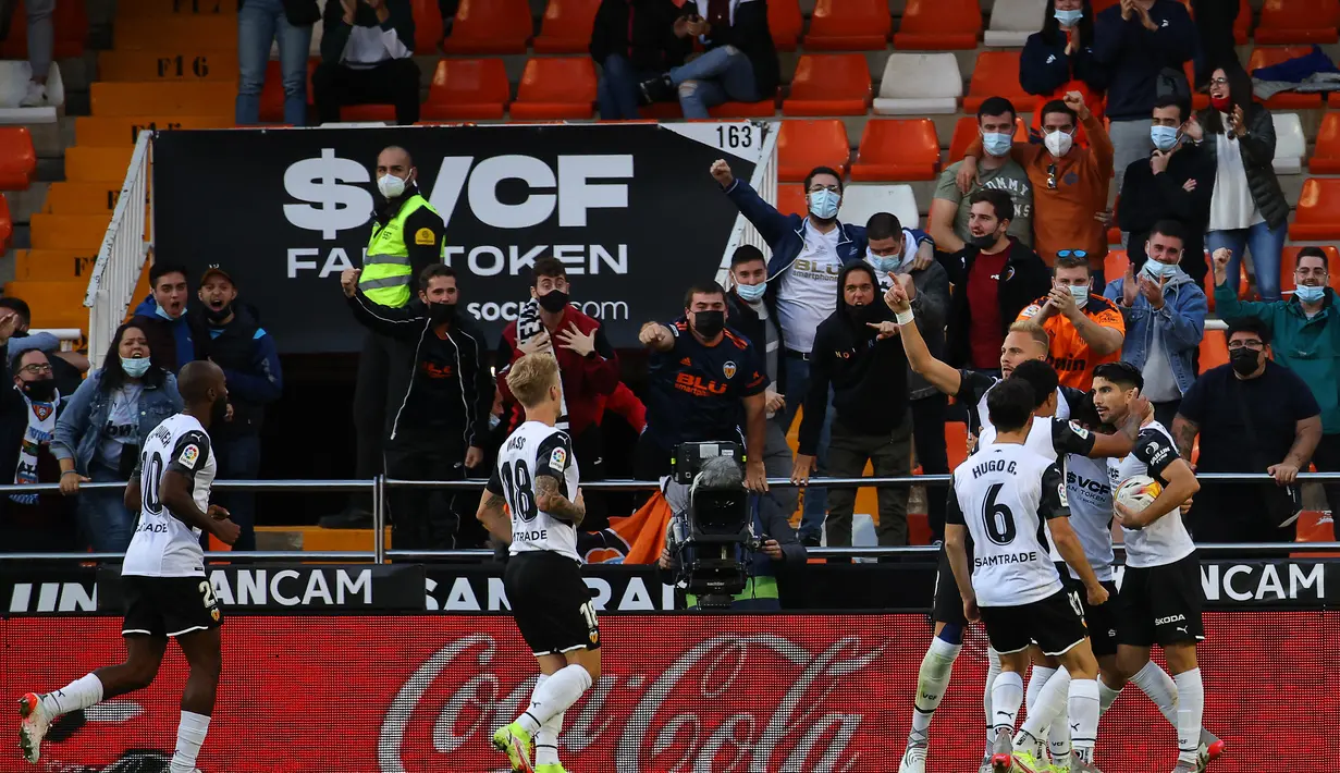 Para pemain Valencia melakukan selebrasi setelah bek Atletico Madrid Stefan Savic mencetak gol bunuh diri pada pertandingan lanjutan La Liga Spanyol di stadion Mestalla di Valencia (8/11/2021). Valencia bermain imbang atas Atletico Madrid 3-3. (AFP/Jose Jordan)