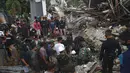 Tim penyelamat mencari korban di antara reruntuhan bangunan yang rusak akibat gempa bumi di Mamuju, Sulawesi Barat, Jumat (15/1/2021). Gempa ini menyebabkan kerusakan parah pada Hotel Maleo, kantor Gubernur Sulbar, serta RSUD Mamuju. (AP Photo/Azhari Surahman)