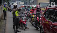 Anggota polisi mengatur lalu lintas saat ganjil genap di kawasan Jalan D.I Panjaitan, Jakarta, Senin (6/6/2022). Perluasan ganjil genap juga sesuai dengan Pergub DKI Jakarta Nomor 88 Tahun 2019. (Liputan6.com/Faizal Fanani)