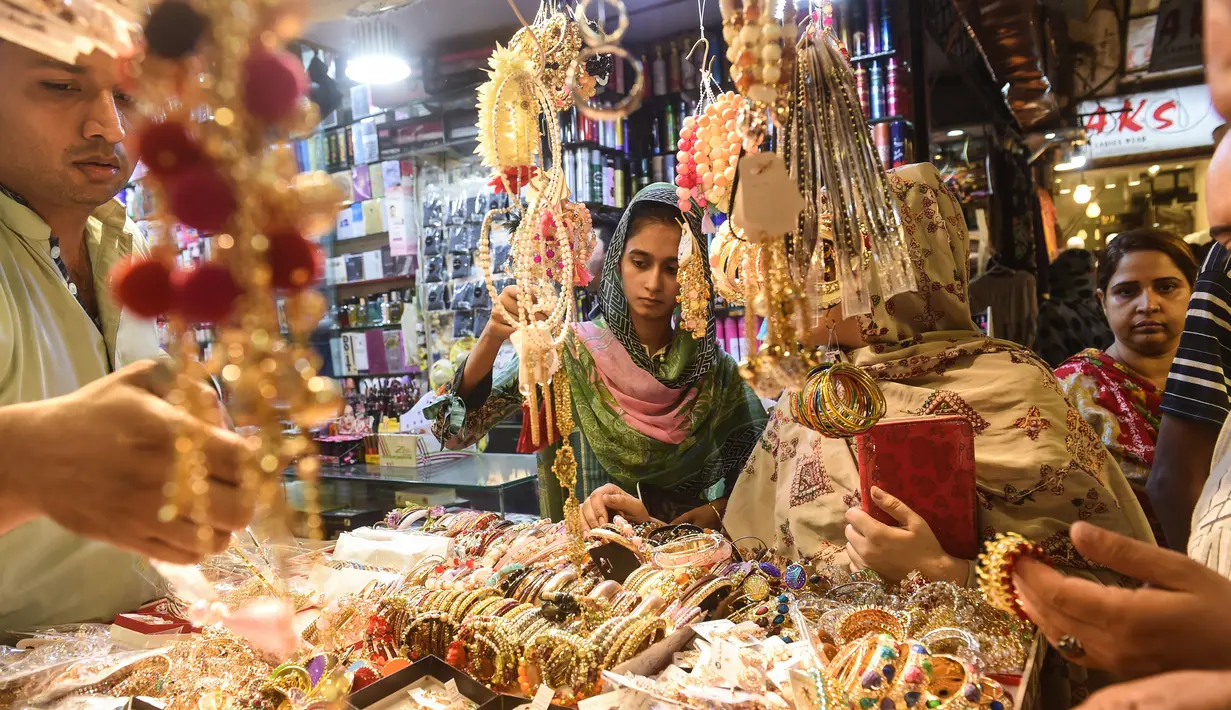 Sejumlah perempuan Pakistan memilih pernak-pernik di sebuah pasar di Lahore, Selasa (12/6). Umat muslim di berbagai penjuru dunia sedang mempersiapkan untuk merayakan Idul Fitri, yang menandai berakhirnya bulan suci Ramadan. (AFP/ARIF ALI)