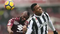 Duel pemain Torino, Nicolas N'Koulou (kiri) dengan pemain Juventus, Alex Sandro pada laga Serie A di Stadio Grande Torino, Turin (18/2/2018). Juventus menang 1-0. (AFP/Marco Bertorello)