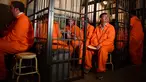 Para pengunjung duduk dalam sel mereka di bar koktail Alcotraz di London Timur, 11 Oktober 2018. Pengunjung harus mengganti pakaian mereka dengan baju tahanan berwarna oranye untuk memasuki bar berkonsep penjara ini. (BEN STANSALL / AFP)