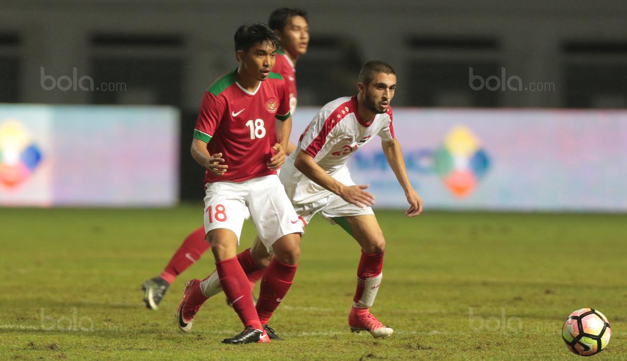 Gaya M.Arfan (kiri) memberikan umpan kepada rekannya saat diadang pemain Suriah U-23 pada laga persahabatan di Stadion Wibawa Mukti, Bekasi, Rabu (16/11/2017). Indonesia kalah 2-3. (Bola.com/NIcklas Hanoatubun)