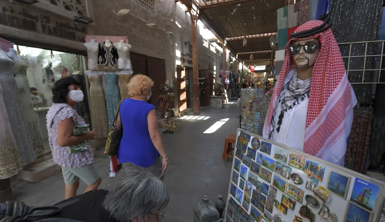 Seorang wanita melihat barang-barang suvenir di Deira Souk di kota Emirat Dubai (30/9/2020). (AFP/Karim Sahib)