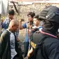 Petugas menggiring terduga pelaku dalam penggerebekan Kampung Boncos, Kota Bambu Selatan, Palmerah Jakarta Barat, Rabu (7/2). (Liputan6.com/ Ady Anugrahadi)