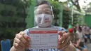 Warga lanjut usia (lansia) menunjukkan kartu vaksinasi Covid-19 di Puskesmas Kecamatan Senen, Jakarta Pusat, Selasa (23/2/2021). Vaksinasi untuk Lansia akan dimulai di ibu kota provinsi untuk seluruh provinsi di Indonesia, di prioritaskan di Jawa-Bali. (Liputan6.com/Herman Zakharia)