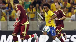Gelandang Brazil Willian (tengah) saat mengumpan bola dari hadangan dua pemain Venezuela selama pertandingan kualifikasi Piala Dunia 2018  di Stadion Fortaleza , Brasil, Rabu (14/10/2015).  Brasil menang dengan skor 3-1. (REUTERS/Paulo Whitaker)