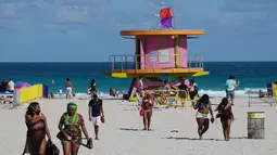 Orang-orang menikmati suasana pantai di Miami, Florida pada Selasa (16/3/2021). Mahasiswa telah tiba di daerah Florida Selatan untuk liburan musim semi tahunan. Para pejabat kota prihatin dengan kerumunan liburan musim semi saat pandemi COVID-19 terus berlanjut. (Joe Raedle/Getty Images/AFP)