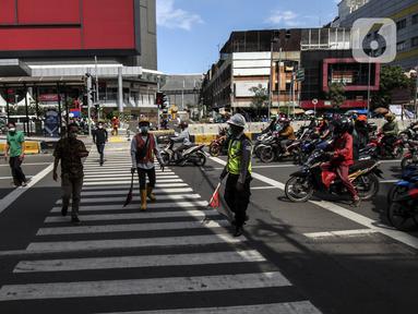 Warga menyeberang jalan menggunakan pelican crossing di kawasan Glodok, Jakarta, Sabtu (22/1/2022). PT Transportasi mulai mengoperasikan Halte Glodok baru dengan rute Blok M - Kota (Koridor 1). (Liputan6.com/Johan Tallo)