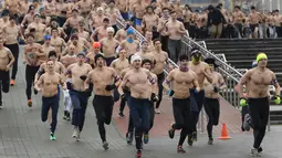 Sejumlah pria berlari dengan setengah telanjang saat berpartisipasi dalam acara "Real men's race" di Minsk, Belarusia, Kamis (23/2). Meski dalam cuaca yang cukup dingin, lomba lari ini mampu menarik partisipasi ratusan peserta. (AP Photo/Sergei Grits)