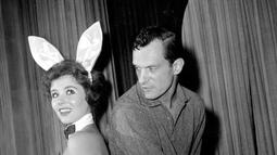 Hugh Hefner berpose dengan seorang wanita di klub malam Hefner, Chicago, pada 20 Juni 1961. Sebelum mendirikan Playboy, Hefner bergabung menjadi tentara dan bekerja sebagai penulis surat kabar militer AS selama dua tahun. (AP Photo/Edward s. Kitch)