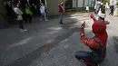 Seorang pria yang mengenakan kostum Spiderman menyapa orang-orang setelah mereka disuntik vaksin covid-19 Pfizer-BioNTech di Mexico City, Meksiko, Selasa (28/12/2021). Spiderman tersebut dipekerjakan oleh Pemerintah Kota untuk menghibur para peserta vaksinasi. (ALFREDO ESTRELLA / AFP)