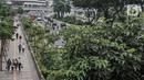 Pekerja melintasi trotoar saat jam pulang kantor di kawasan Sudirman, Jakarta, Senin (14/9/2020). Selama PSBB, Pemprov DKI Jakarta mewajibkan perusahaan nonesensial untuk membatasi 25 persen dari total pekerja yang bekerja di kantor guna memutus penyebaran Covid-19. (merdeka.com/Iqbal S. Nugroho)