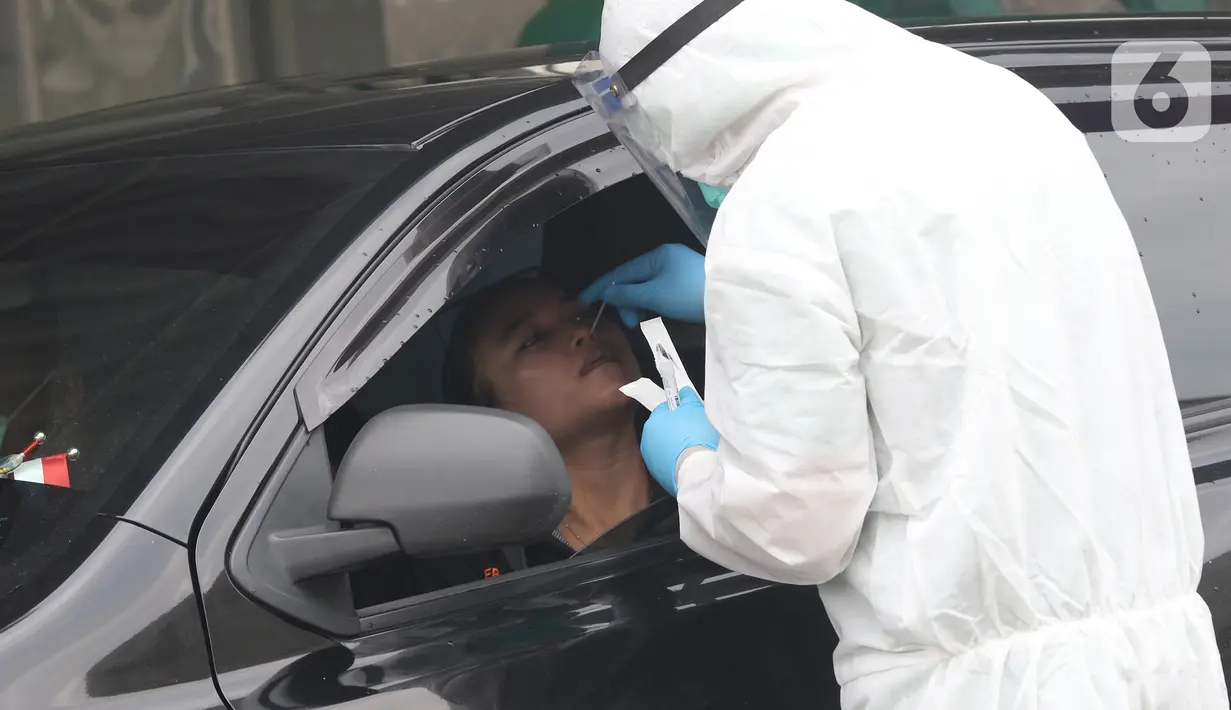 Tenaga kesehatan menggunakan alat pelindung diri (APD) melakukan tes swab di GSI Lab (Genomik Solidaritas Indonesia Laboratorium), Jakarta, Sabtu (3/10/2020). Pemerintah telah menyepakati batas maksimal harga tes usap atau swab mandiri sebesar Rp900 ribu. (Liputan6.com/Herman Zakharia)