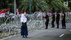 Personel Brimob memasang kawat berduri di sekitar area gedung KPU, Jakarta, Jumat (1/3). Kawat berduri itu untuk mengantisipasi massa Forum Umat Islam (FUI) dan Gerakan Jaga Indonesia yang akan menggelar aksi di depan KPU. (Liputan6.com/Faizal Fanani)