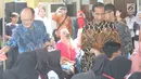 Presiden Bank Dunia, Jim Yong Kim membagikan buku tulis didampingi Presiden Joko Widodo (Jokowi) saat blusukan di PAUD Desa Tangkil, Kecamatan Caringin, Bogor, Rabu (4/8). Keduanya berangkat usai pertemuan di Istana Bogor (Liputan6.com/Angga Yuniar)