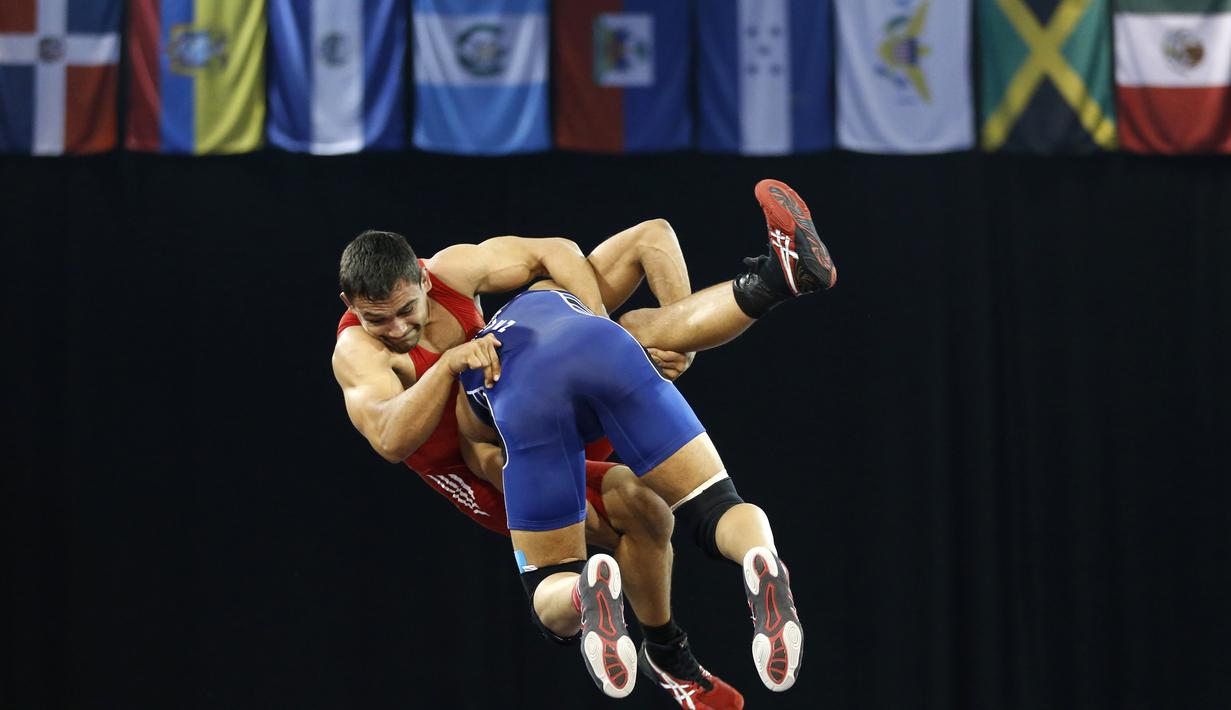 Pegulat Kosta RiKa, Johnathan Scott (kanan), berusaha di jatuhkan pegulat Venezuela, Cristian Sacro, dalam gulat gaya bebas 74 kg Pan Am Games 2015 di Mississauga, Ontario, Kanada. (18/7/2015). (AP Photo/Julio Cortez)
