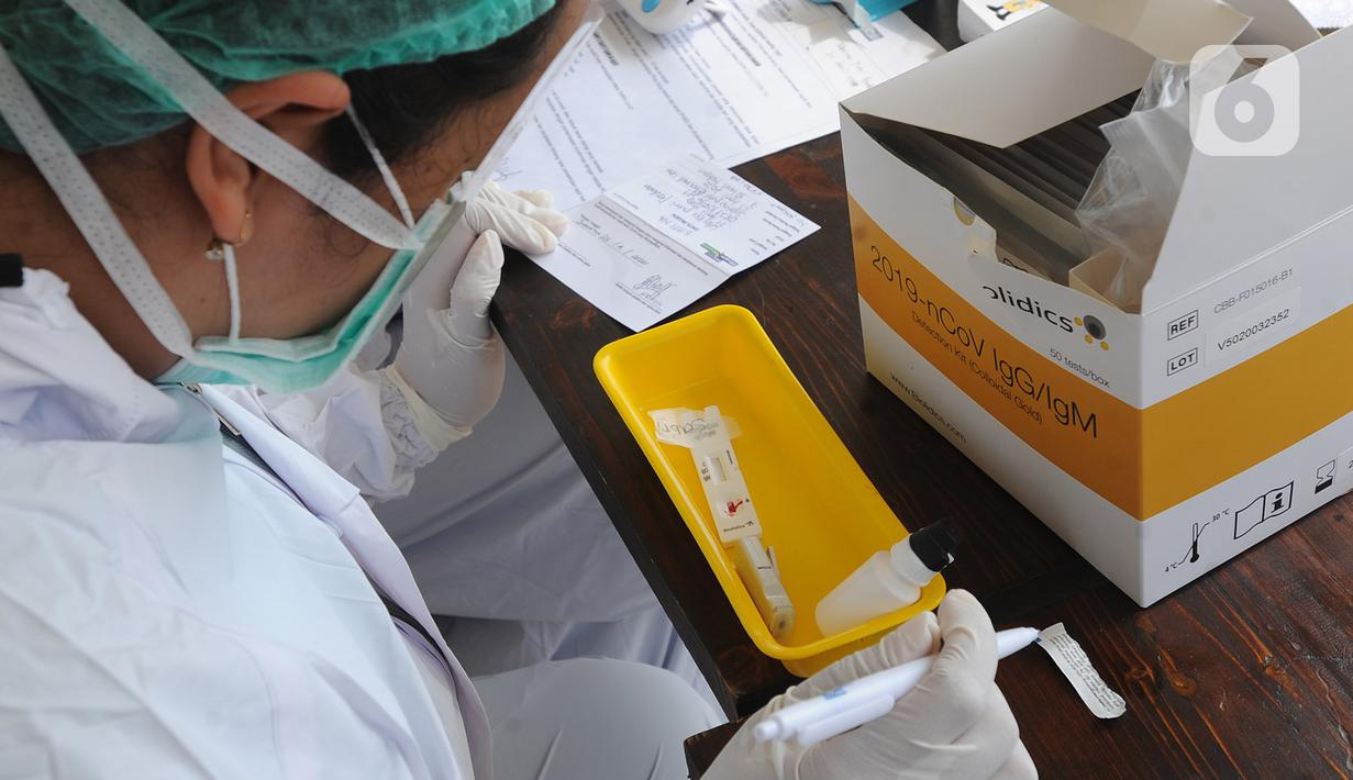Paramedis Siloam Hospitals memeriksa sampel darah saat Rapid Test mandiri COVID -19 secara drive thru di Akses Senayan Park Jalan Gerbang Pemuda, Jakarta, Kamis (23/4/2020). Rapid Tes Covid -19 dibanderol seharga Rp 489.000, periode 17-30 April 2020 pukul 08.00-10.00 WIB. (merdeka.com/Arie Basuki)