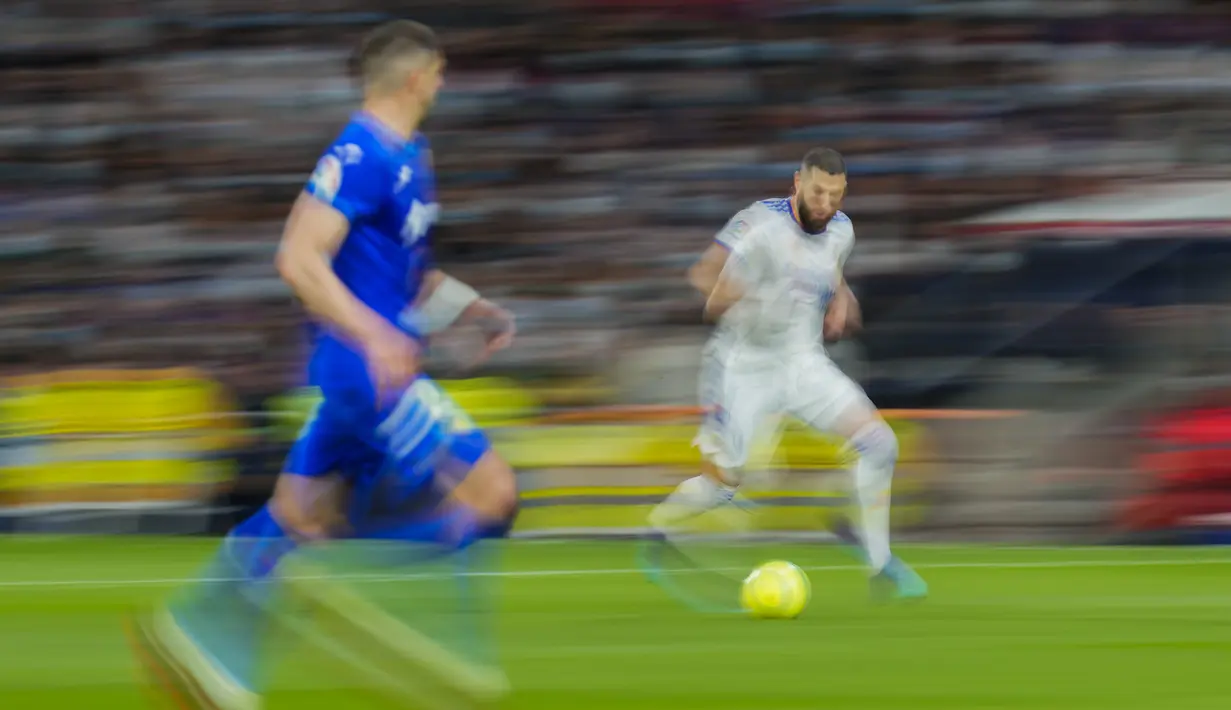 Penyerang Real Madrid, Karim Benzema membawa bola saat bertanding melawan Getafe pada pertandingan lanjutan La Liga Spanyol di stadion Santiago Bernabeu di Madrid, Minggu (10/4/2022). Real Madrid menang atas Getafe 2-0. (AP Photo/Manu Fernandez)