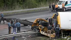 Personel darurat memeriksa kondisi bus sekolah yang bertabrakan dengan truk sampah di Interstate 80, Mount Olive, New Jersey, Kamis (17/5). Akibat kecelakaan itu, seorang siswa dan seorang guru tewas, serta lebih dari 40 orang terluka. (AP/Seth Wenig)