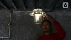 Pekerja menyalakan lampu menggunakan bahan bakar biogas yang mengubah kotoran sapi menjadi gas untuk kebutuhan tumah tangga di kawasan Pancoran, Jakarta, Selasa (12/12/2023). (Liputan6.com/Herman Zakharia)