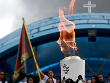 Warga menyaksikan parade obor Olimpiade yang melintas di Itamaraju, Kota Bahia , Brasil,(19/5/2016). Olimpiade akan dilaksanakan di Rio De Jeneiro.  (AFP/Marcos de Paula)