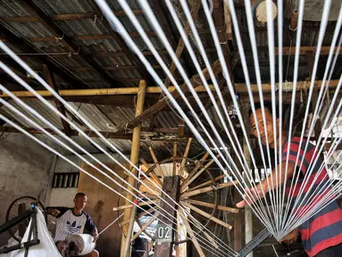 Pekerja memintal benang di sebuah industri rumahan yang ada di kawasan Kebayoran Lama, Jakarta, Minggu (11/5/2025). (Liputan6.com/Angga Yuniar)