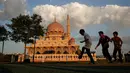 Anak-anak bermain di halaman masjid berwarna pink, kawasan Putrajaya, Malaysia. Salah satu landmark yang terkenal dari Putrajaya ini dibangun pada tahun 1997 oleh PM Mahathir Mohammad dan bisa menampung 15.000 jemaah. (File, AP Photo/Joshua Paul)