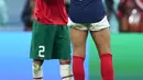 Penyerang #10 Prancis Kylian Mbappe menyapa bek Maroko #02 Achraf Hakimi setelah babak semifinal Piala Dunia 2022 di Al Bayt Stadium, Kamis (15/12/2022) dini hari WIB. Mbappe pun memeluk Hakimi bahkan keduanya juga tampak saling bertukar jersey. (AP Photo/Natacha Pisarenko)