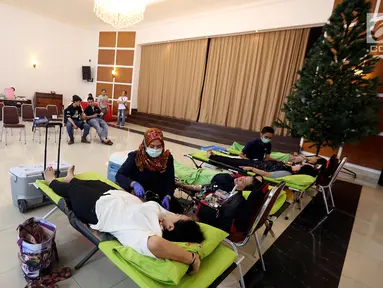 Petugas muslim dari Palang Merah Indonesia (PMI) membantu Jemaat Gereja Protestan Indonesia Bagian Barat (GPIB) dalam donor darah, Jakarta, Minggu (3/12). Kegiatan tersebut diadakan dalam rangkaian acara Natal. (Liputan6.com/JohanTallo)