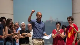 Pelatih Manchester City Pep Guardiola membacakan manifesto referendum Catalonia di Barcelona, Minggu (11/6). Mantan pelatih Barcelona ini juga meminta dunia internasional mendukung keinginan Catalonia untuk berpisah dari Spanyol. (AP/Emilio Morenatti)