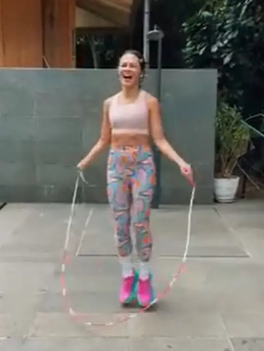 Andien tampil playful saat bermain skipping sebagai aktivitas olahraganya. Ia mengenakan croptop berwarna peach yang dipadukan dengan legging bermotif. Sepatu yang dikenakannya pun tidak kalah mentereng dengan memadukan warna pink dan biru. (instagram/andienaisyah)