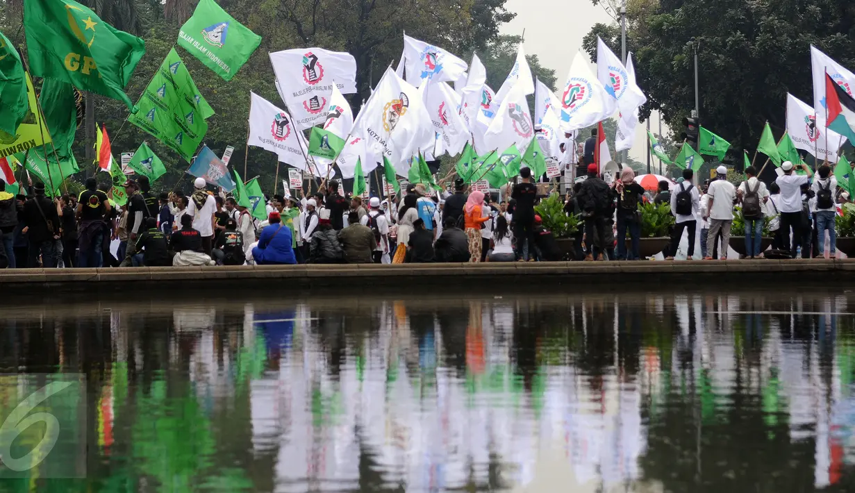 Ratusan massa aksi damai berkumpul di sekitar BundaranPatung Arjuna Wijaya, Jakarta, Jumat (4/11). Massa berkumpul untuk melakukan aksi di depan Istana Negara menuntut penegakan hukum kasus dugaan penistaan agama. (Liputan6.com/Helmi Fithriansyah)