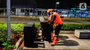 Pasukan oranye mengumpulkan sampah di tengah Pandemi Covid-19, Jakarta, Jumat (8/5/2020). Semenjak diberlakukan Pembatasan Sosial Berskala Besar (PSBB) yang diterapkan Ibu Kota membuat aktivitas warga berkurang dan jalan menjadi lengang. (merdeka.com/Imam Buhori)