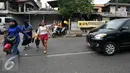 Pejalan kaki menyeberang meski terdapat tulisan agar tidak menyeberang sembarangan di jalan raya Lenteng Agung, Jakarta (3/12). Ironisnya, tak jauh dari lokasi terdapat Jembatan Penyeberangan Orang (JPO) yang masih berfungsi. (Liputan6.com/Yoppy Renato)