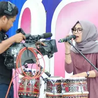 Terlihat kalem dengan gaya hijab dan busananya, ternyata wanita ini garang bermain kendang.