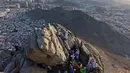 Peziarah muslim berfoto di Jabal al-Noor atau Gunung Cahaya yang menghadap ke Kota Suci Mekkah, Arab Saudi, 5 Juli 2022. Satu juta orang, termasuk 850 ribu dari luar negeri, diizinkan untuk berpartisipasi dalam haji tahun ini setelah dua tahun terakhir jumlahnya dikurangi secara drastis karena pandemi virus corona COVID-19. (Christina ASSI/AFP)