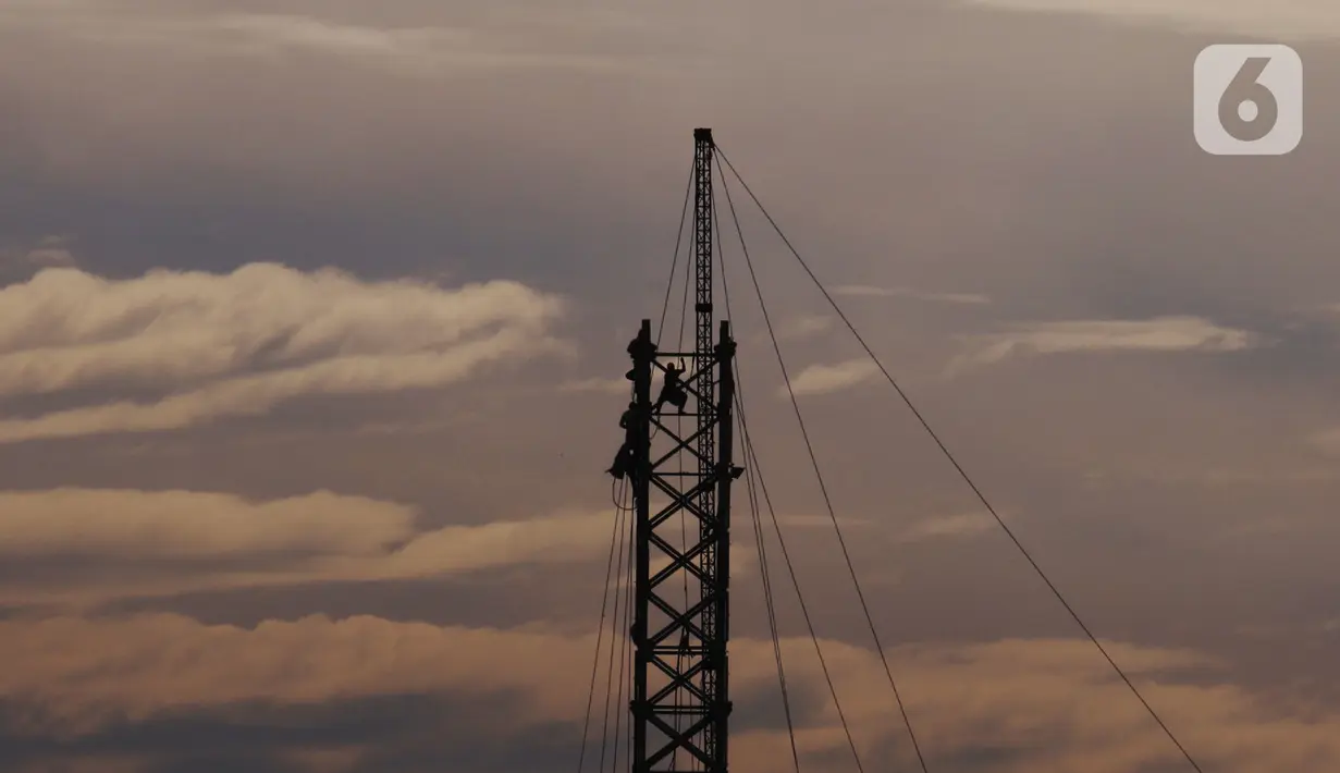 Pekerja tengah melakukan aktivitas kerja pada ketinggian di menara sutet di kawasan Karang Tengah, Kota Tangerang, Banten, Jumat (8/1/2021). Keselamatan dan kesehatan kerja (K3) merupakan hal yang mutlak bagi para pekerja di ketinggian dengan risiko tinggi. (Liputan6.com/Angga Yuniar)