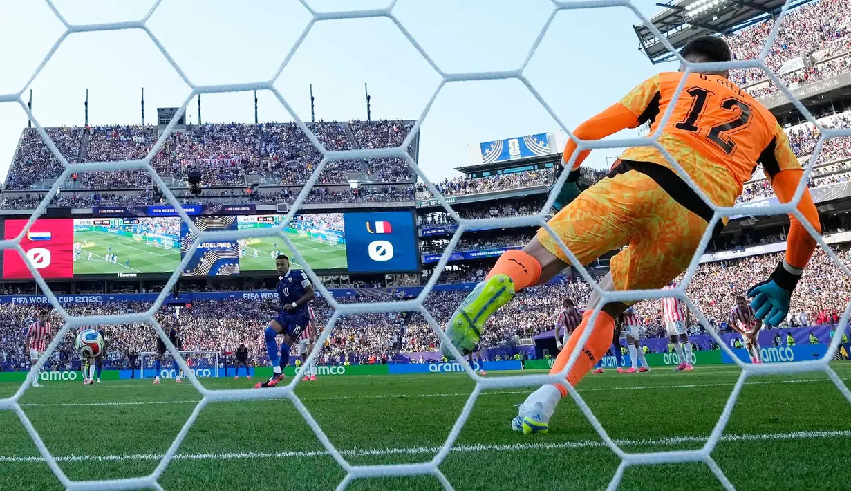 Pemain Prancis Kylian Mbappe mencetak gol dari titik penalti melewati kiper Paraguay Orlando Gill (12) saat pertandingan sepak bola babak 16 besar Piala Dunia antara Paraguay dan Prancis di Philadelphia, Sabtu (04/07/2026). (AP Photo/Matt Slocum)
