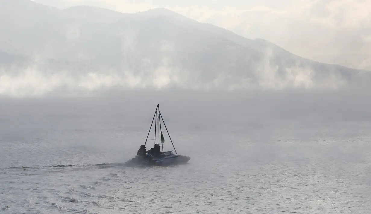 Sebuah perahu mesin melintasi Sungai Yenisei ditengah kabut dingin di Taiga luar kota Siberia Krasnoyarsk, Rusia, Selasa (17/11/2015). Suhu udara minus hingga 20 derajat Celsius. (REUTERS/Ilya Naymushin)
