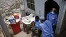 Seorang perawat memberikan suntikan vaksin Sinopharm COVID-19 kepada Wilber Guzman di rumahnya, selama kampanye vaksinasi dari rumah ke rumah di lingkungan Villa Maria del Triunfo, Lima, Peru, Rabu (13/10/2021). (AP Photo/Martin Mejia)