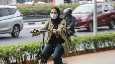 Warga melintas memakai masker untuk melindungi diri dari debu di Jalan Sudirman,Jakarta, Selasa (15/8/2023). (Liputan6.com/Faizal Fanani)